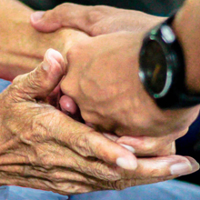 man's hands holding an older woman's hands